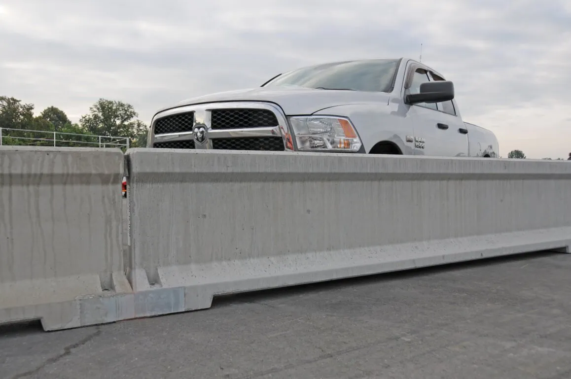 Photo of a work truck monitoring concrete barrier system.